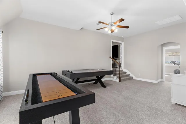 a room with chandelier fan and windows