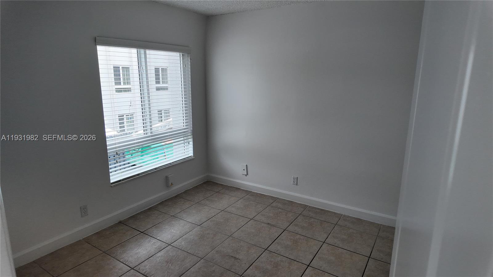 11120 Southwest 196th Street, Unit 201 Cutler Bay, FL 33157 - Photo 11 of 18 a view of an empty room with a window