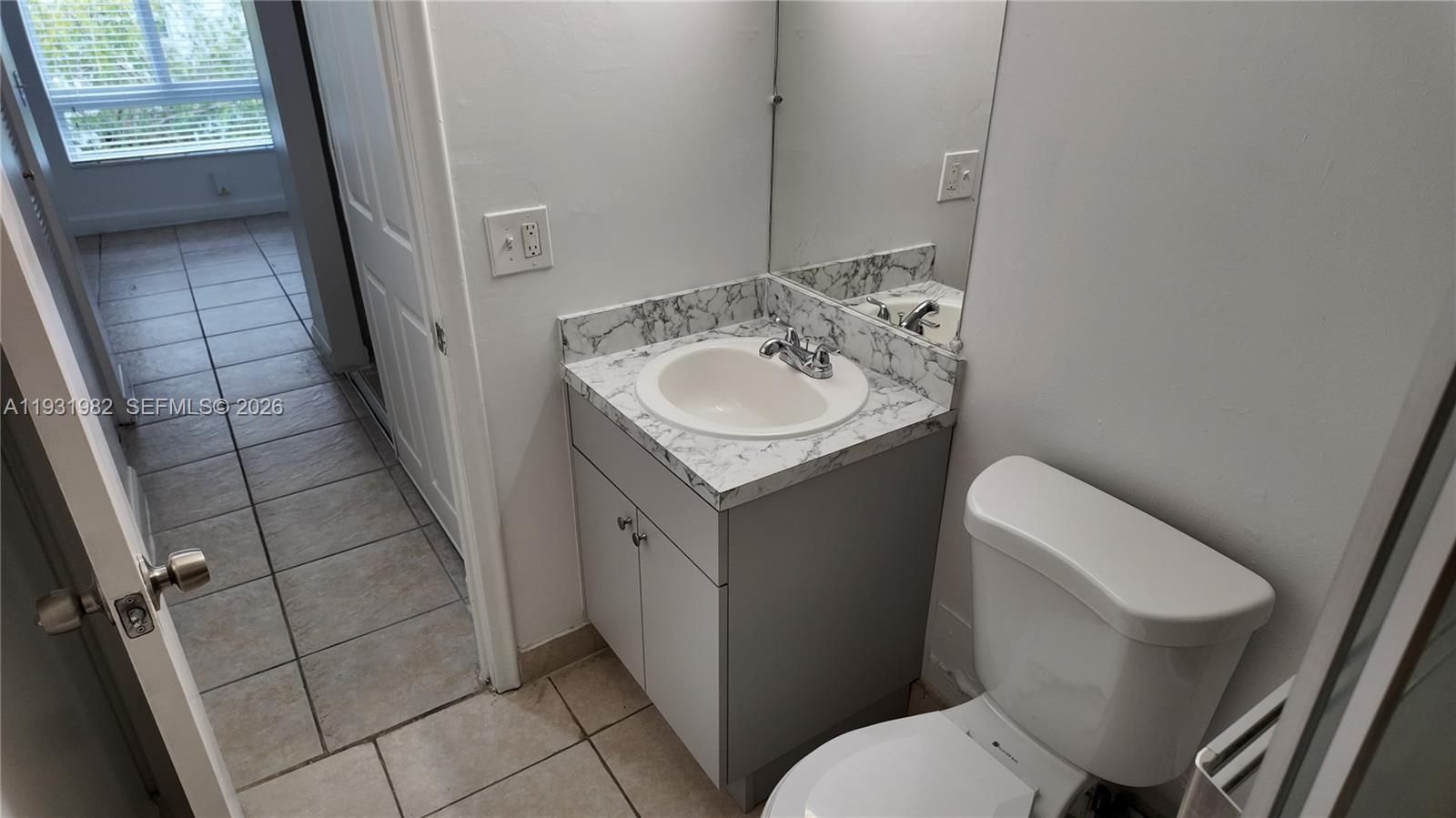 11120 Southwest 196th Street, Unit 201 Cutler Bay, FL 33157 - Photo 13 of 18 a bathroom with a sink toilet and mirror