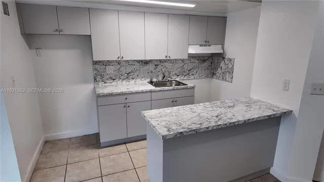 a kitchen with a sink a stove and cabinets