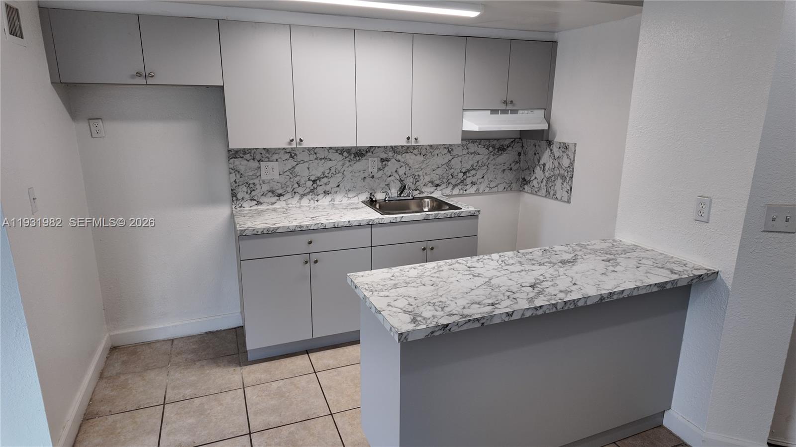 11120 Southwest 196th Street, Unit 201 Cutler Bay, FL 33157 - Photo 4 of 18 a kitchen with a sink a stove and cabinets