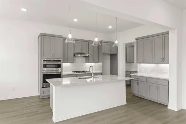 a kitchen with appliances a sink and cabinets