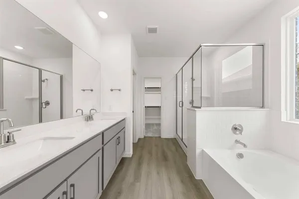 a spacious bathroom with a tub sink and mirror
