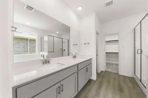 a bathroom with a sink double vanity and a large mirror