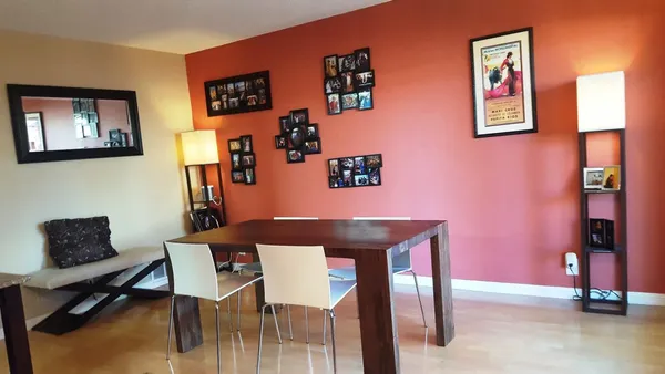 a living room with furniture and paintings on the wall