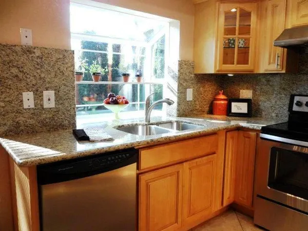 a kitchen with stainless steel appliances granite countertop a sink and a microwave
