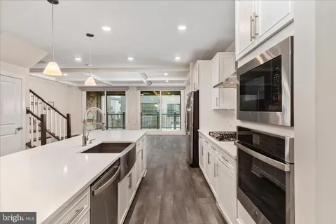 a kitchen with counter top space stainless steel appliances and wooden floor