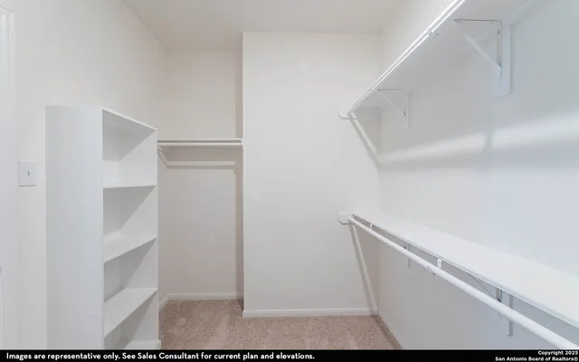 a view of walk in closet with empty racks