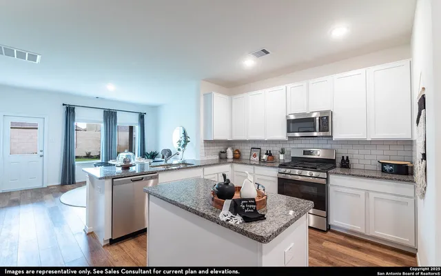 a kitchen with stainless steel appliances kitchen island granite countertop a sink stove and cabinets