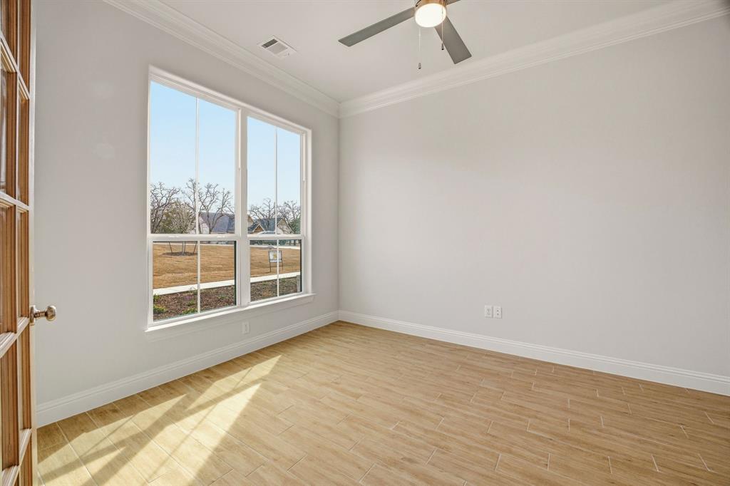 2017 Forest Bridge Azle, TX 76020 - Photo 6 of 30 Empty room with light wood-style floors, crown molding, and a ceiling fan