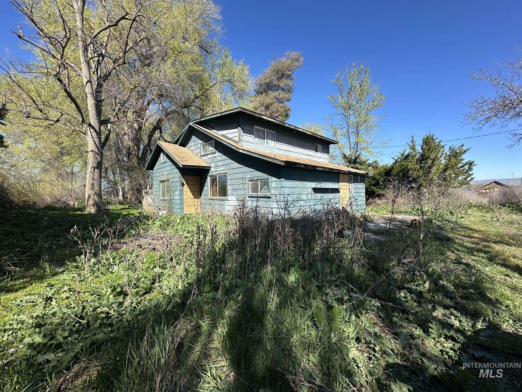 450 Annex Road Ontario, OR 97914 - Photo 1 of 1 Two-story residence with light blue siding and a brown roof, featuring multiple windows and a covered entryway