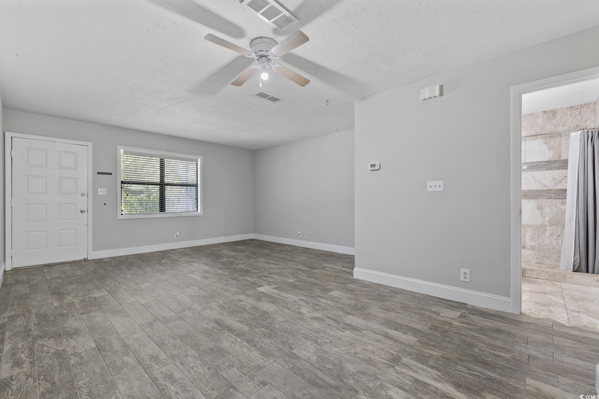 801 Burcale Road, Unit I1 Myrtle Beach, SC 29579 - Photo 4 of 27 Spare room featuring light wood-style flooring, a textured ceiling, and a ceiling fan
