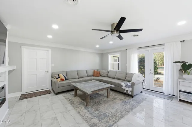 a living room with stainless steel appliances kitchen island furniture and flat screen tv