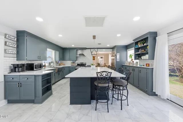 a kitchen with a table chairs sink and cabinets