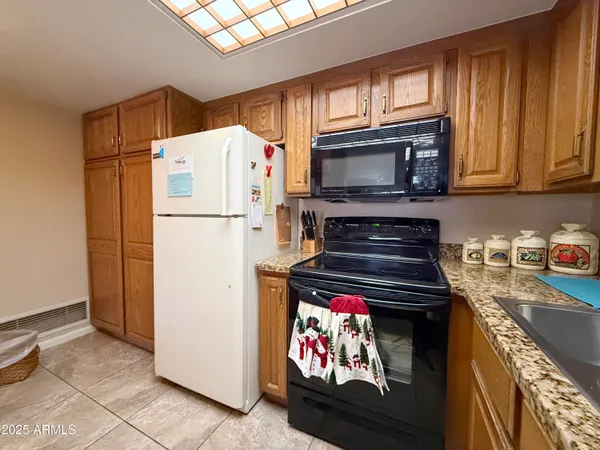 a kitchen with granite countertop a refrigerator stove and microwave