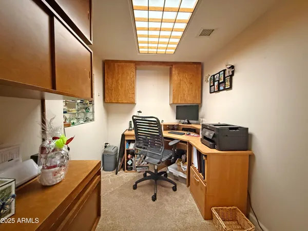a view of a workspace with furniture and a window