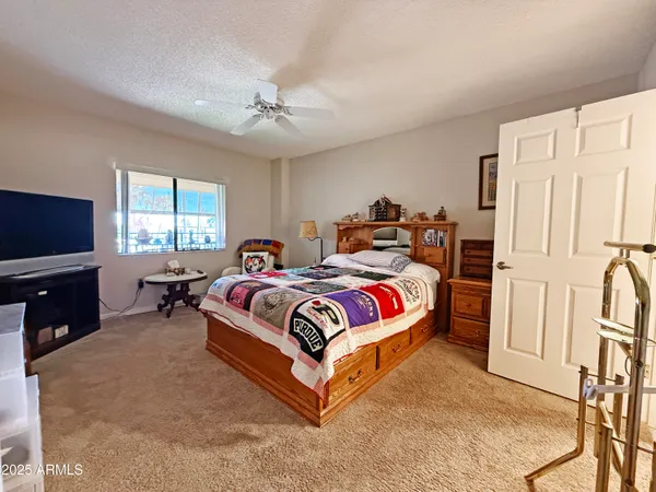 a spacious bedroom with a bed and a flat screen television