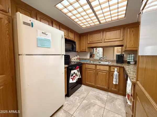 a kitchen with stainless steel appliances granite countertop a refrigerator a sink a stove a microwave and cabinets