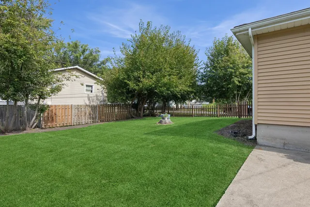 a view of a house with backyard and a tree