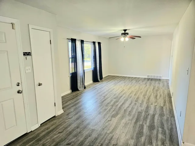 wooden floor in an empty room with a window