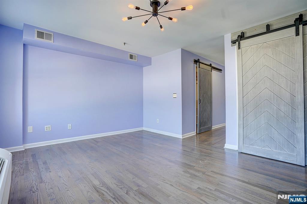 54 Polk Street, Unit P3 Newark, NJ 07105 - Photo 11 of 26 a view of an empty room with wooden floor and a ceiling fan