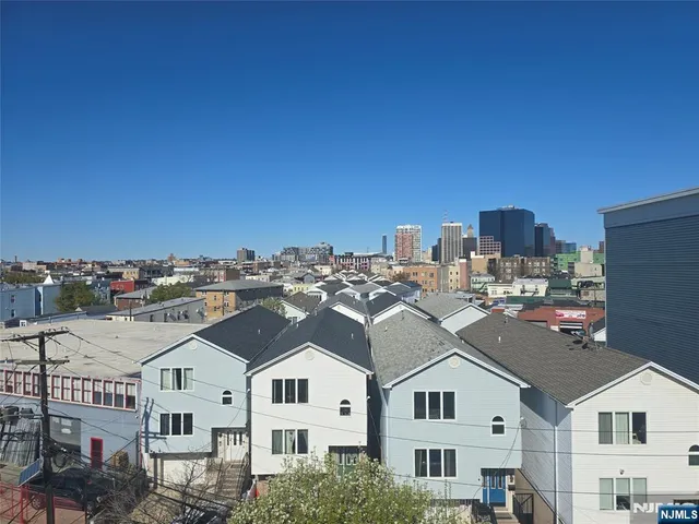 a view of an empty room with wooden floor and a stairs