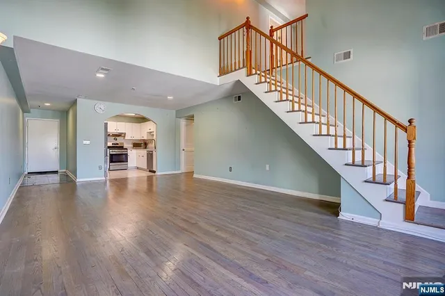 a view of a hallway with wooden floor and stairs