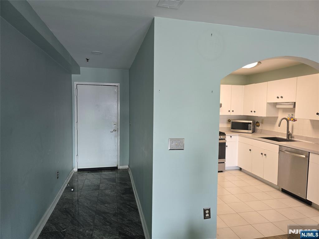 54 Polk Street, Unit P3 Newark, NJ 07105 - Photo 7 of 26 a kitchen with granite countertop a sink and white cabinets