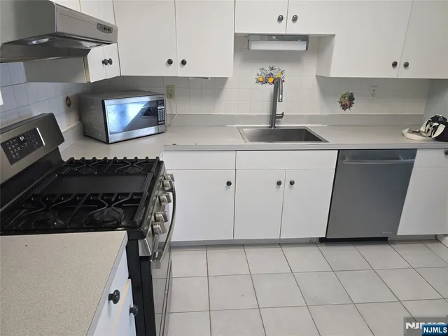 a kitchen with a sink a stove and cabinets