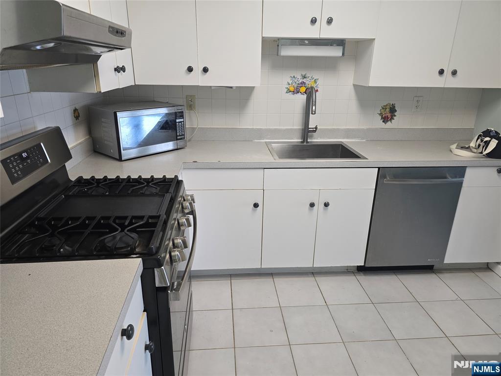 54 Polk Street, Unit P3 Newark, NJ 07105 - Photo 9 of 26 a kitchen with a sink a stove and cabinets