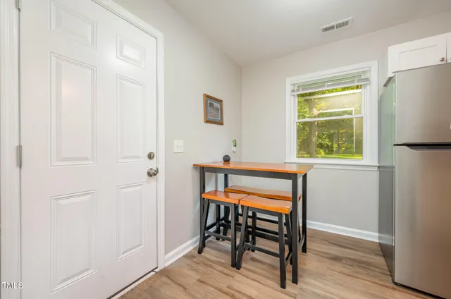a view of a hallway that has a dining table and a window in it