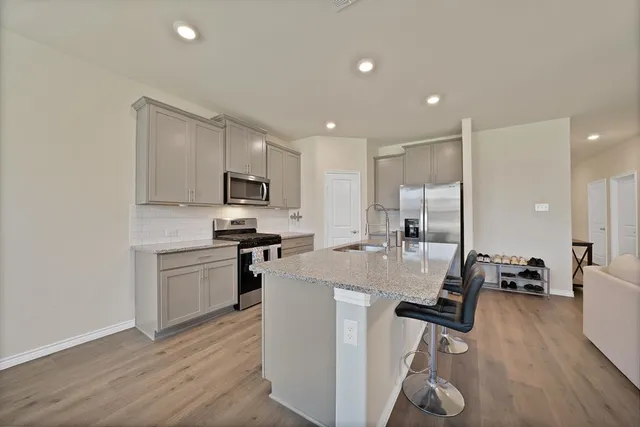 a kitchen with sink refrigerator and microwave