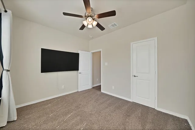 a view of an empty room with a ceiling fan