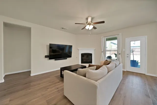 a living room with furniture a flat screen tv and a fireplace
