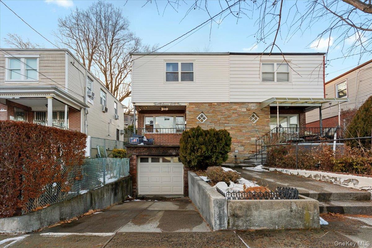 2761 Hering Avenue Bronx, NY 10469 - Photo 2 of 29 Back of property featuring driveway, a garage, and stone siding