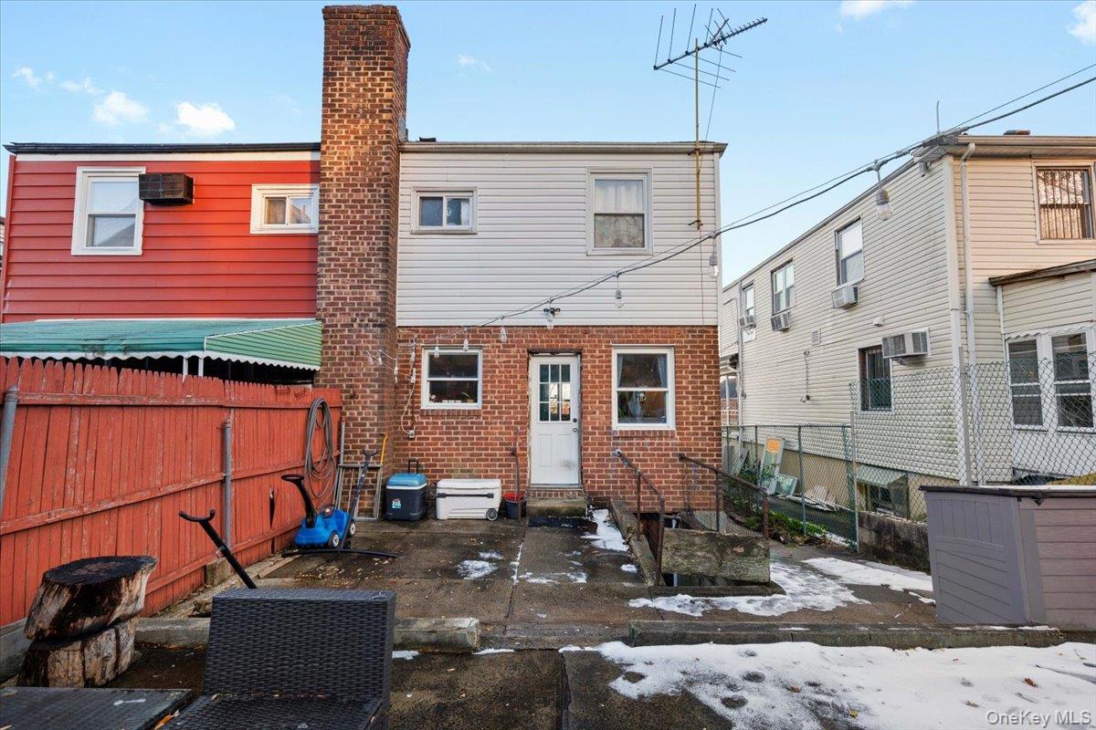 2761 Hering Avenue Bronx, NY 10469 - Photo 22 of 29 Back of house featuring a patio, brick siding, a wall unit AC, and entry steps