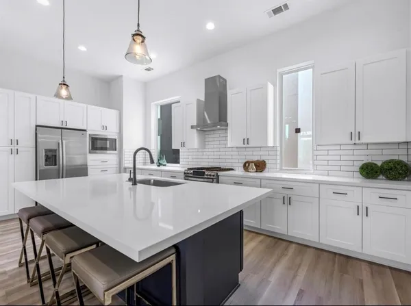 a large kitchen with kitchen island a sink table and chairs