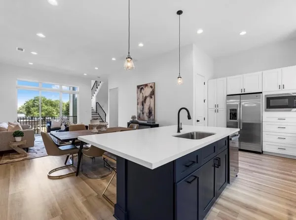 a kitchen with a table chairs and white cabinets