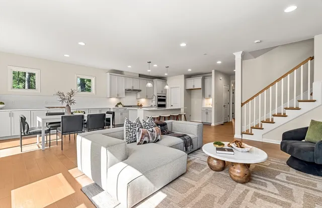 a living room with lots of furniture and view of kitchen