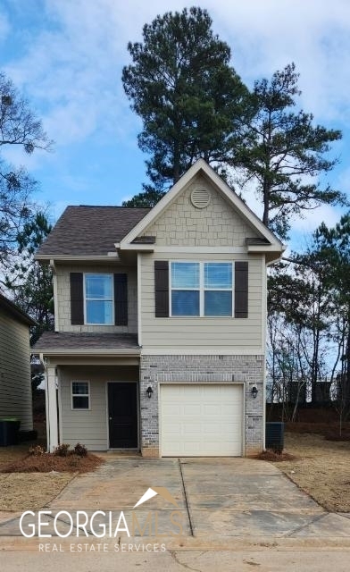 11946 Quail Drive, Unit 6 Hampton, GA 30228 - Photo 1 of 1 a front view of a house with a garden
