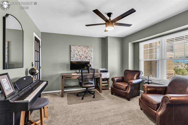 182 Raptor Court Canon City, CO 81212 - Photo 11 of 50 Located just off the front entry, this versatile space features plush carpet, a window overlooking the front yard, French doors to the entry, and an additional door leading to the hallway near the stairs, offering both privacy and flexibility for multiple uses.