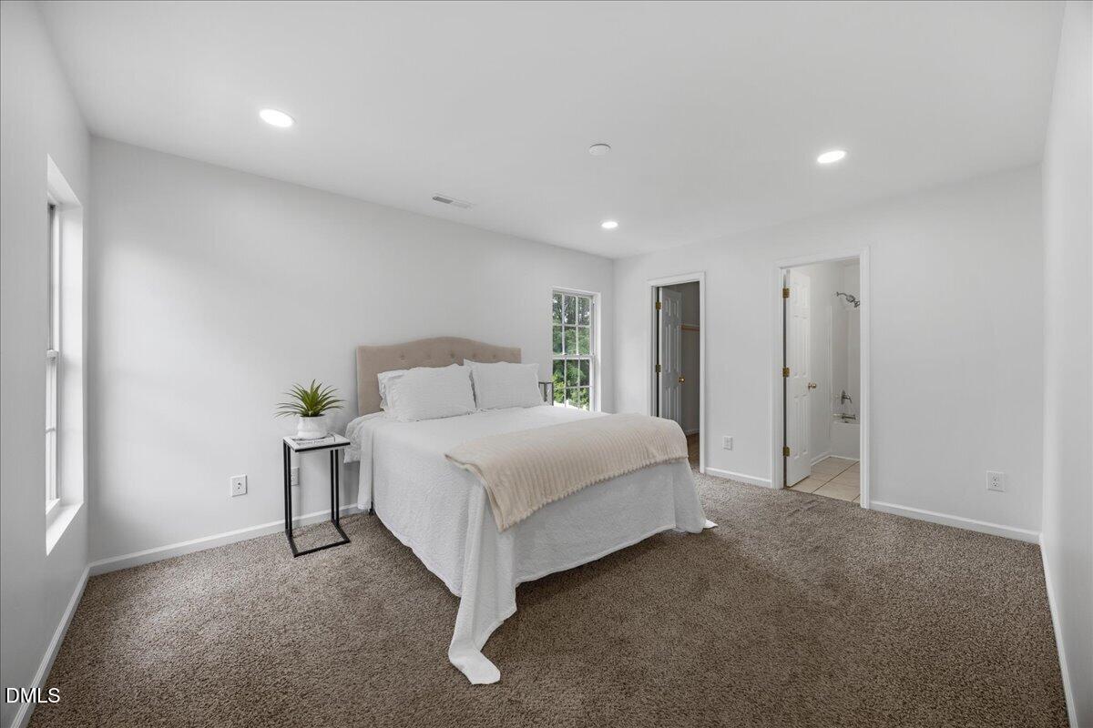 3831 Pin Oak Road Raleigh, NC 27604 - Photo 12 of 24 a spacious bedroom with a bed and a cabinets