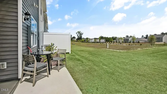a view of a swimming pool with lawn chairs and a large tree