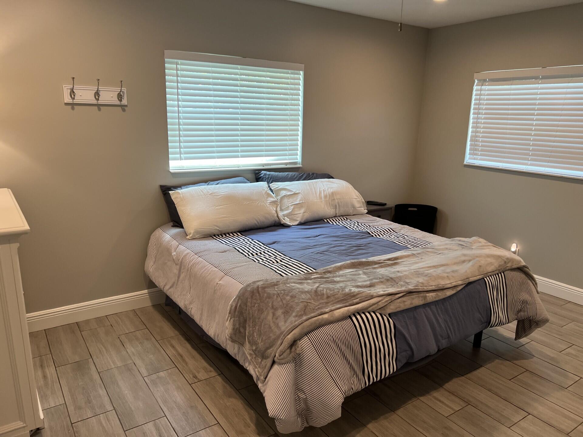 3125 Albatross Road, Unit B Delray Beach, FL 33444 - Photo 12 of 16 a bedroom with a bed and wooden floor