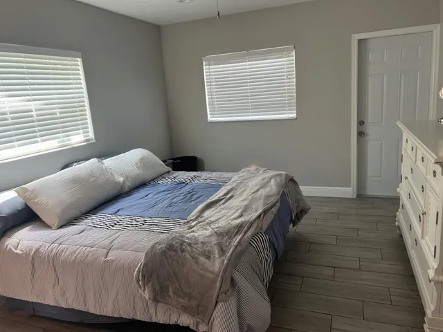 a bedroom with a bed next to a window