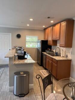 3125 Albatross Road, Unit B Delray Beach, FL 33444 - Photo 4 of 16 a kitchen with stainless steel appliances granite countertop a sink a stove a refrigerator cabinets and chairs