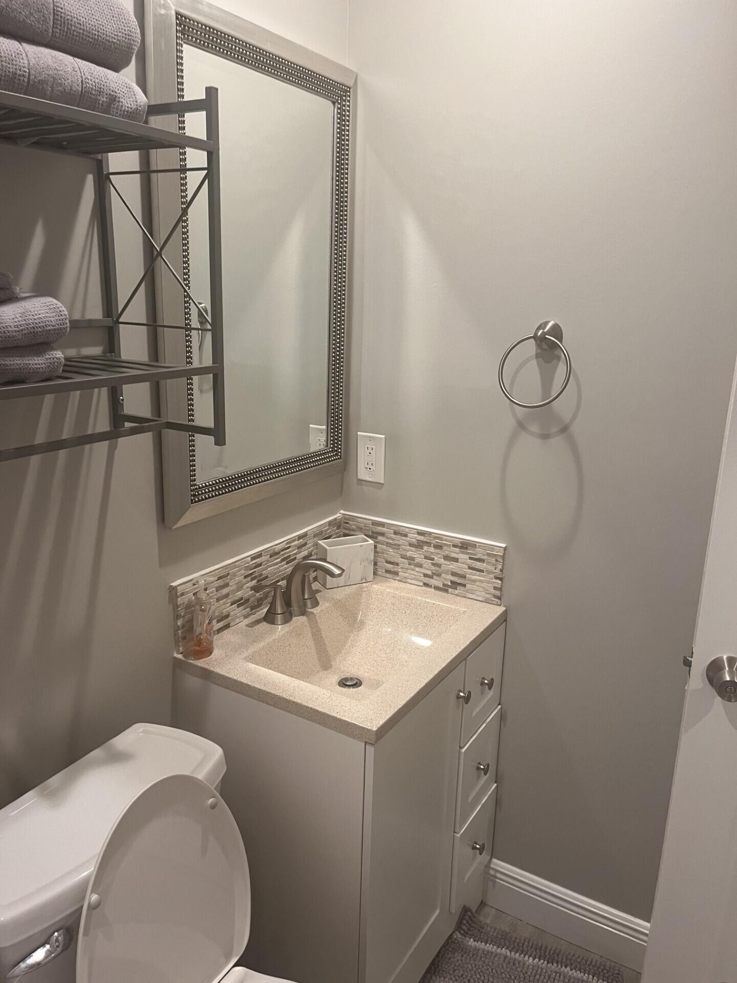 3125 Albatross Road, Unit B Delray Beach, FL 33444 - Photo 10 of 16 a bathroom with a sink and mirror with toilet