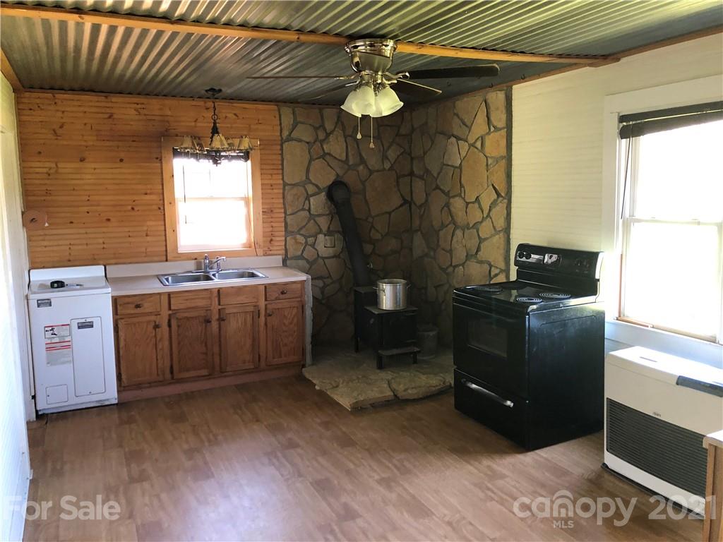200 Lake Logan Road Canton, NC 28716 - Photo 22 of 41 a kitchen with a sink cabinets and wooden floor