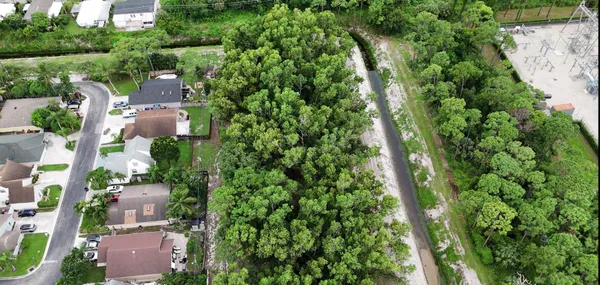 an aerial view of residential houses with outdoor space and trees