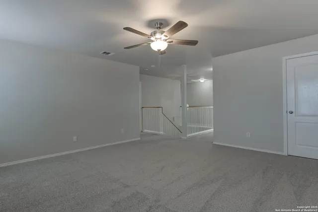 an empty room with closet and ceiling fan